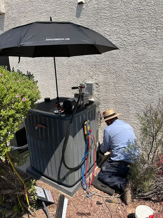 HVAC technician performing outdoor AC maintenance in Peoria Heights
